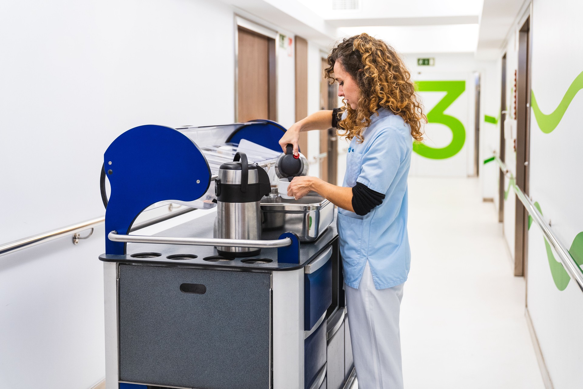 Personal sanitario preparando café en el pasillo del hospital